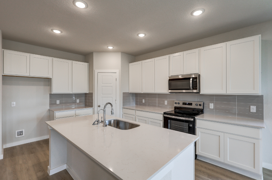 A kitchen with white cabinets.
