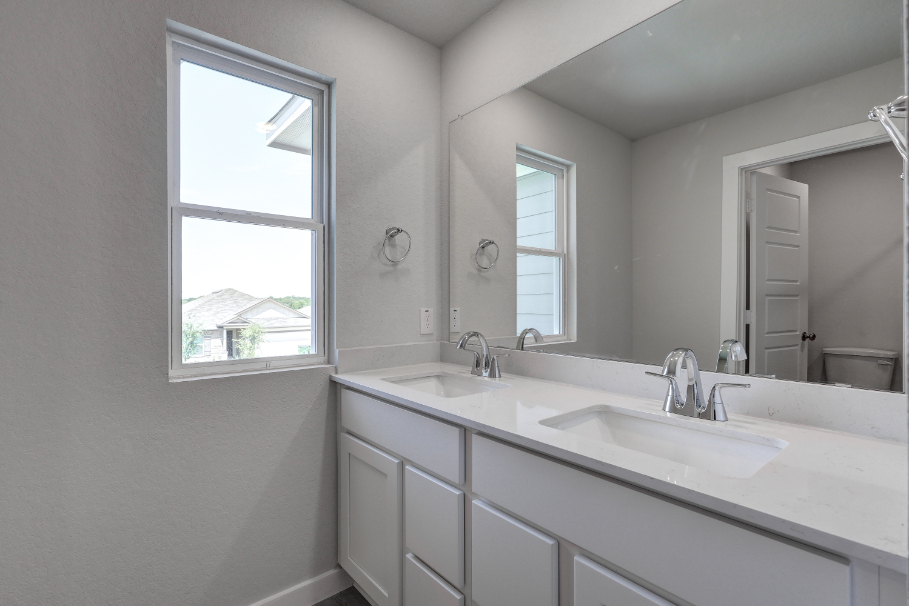 A bathroom with a large mirror.