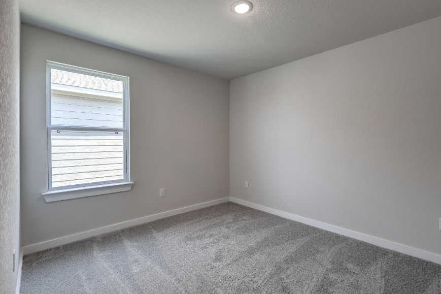 A room with a window and carpet.