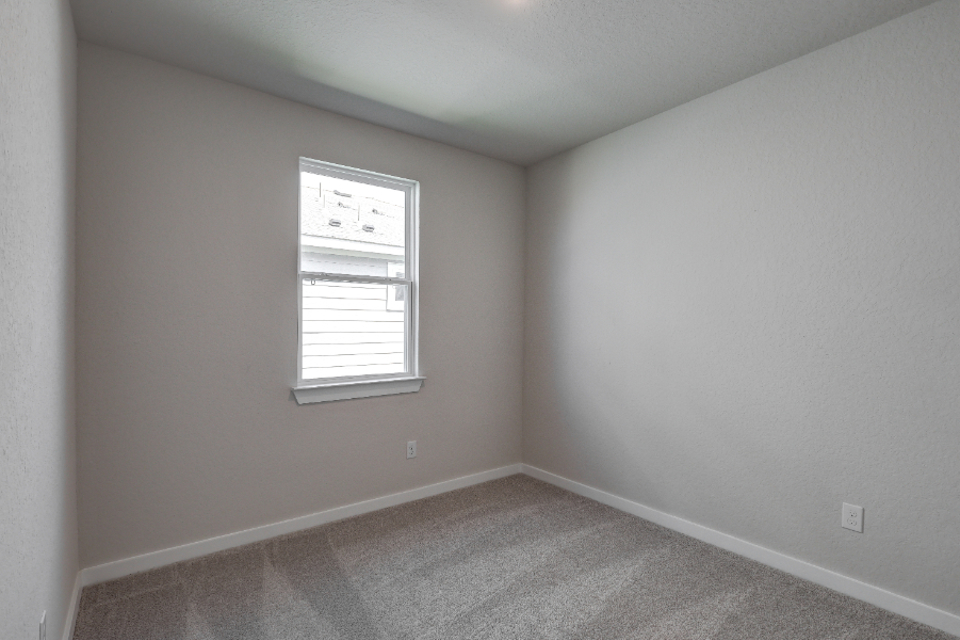 A room with a window and a carpet.