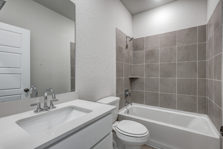 A bathroom with a sink toilet and bathtub.