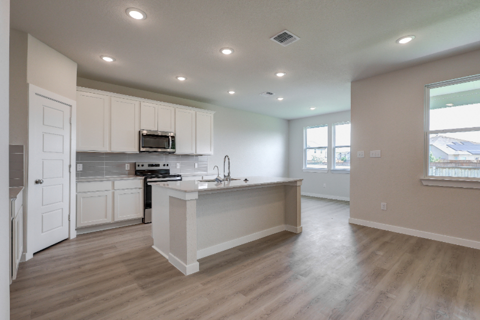 A kitchen with white cabinets.