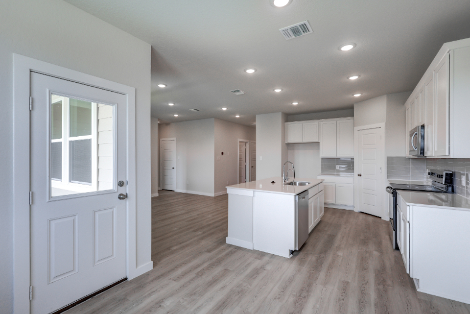 A kitchen with white cabinets.