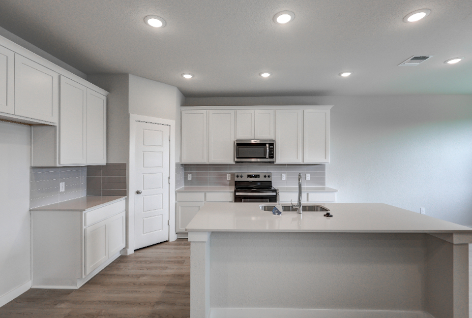 A kitchen with white cabinets.