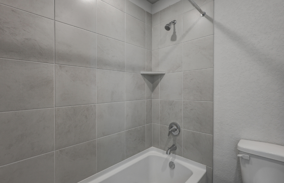 A bathroom with a bathtub and toilet.