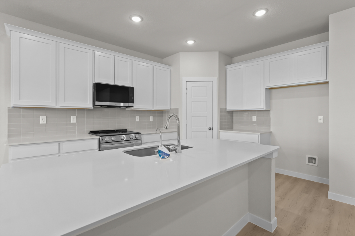 A kitchen with white cabinets.