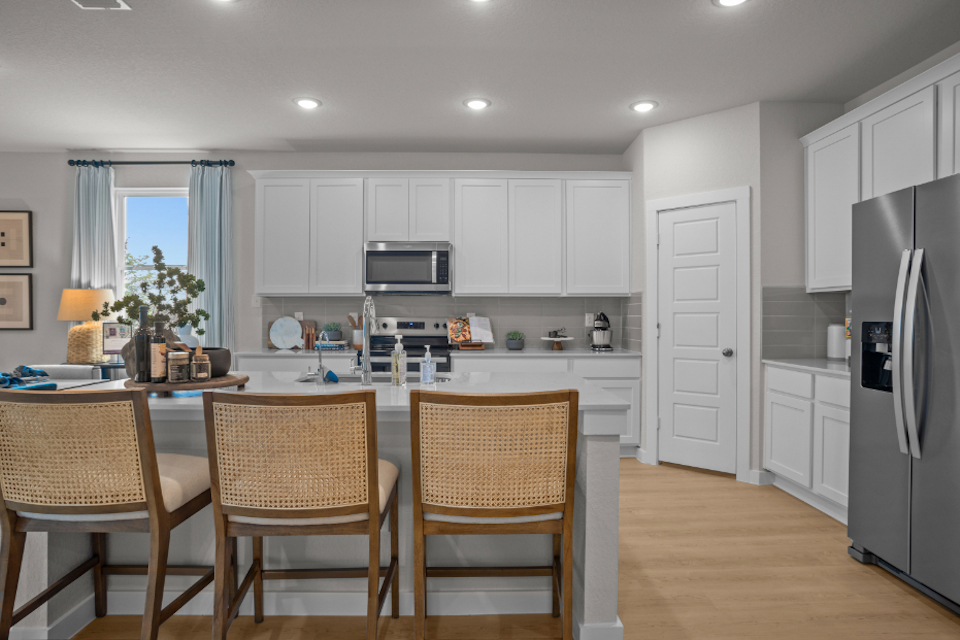 A kitchen with white cabinets.