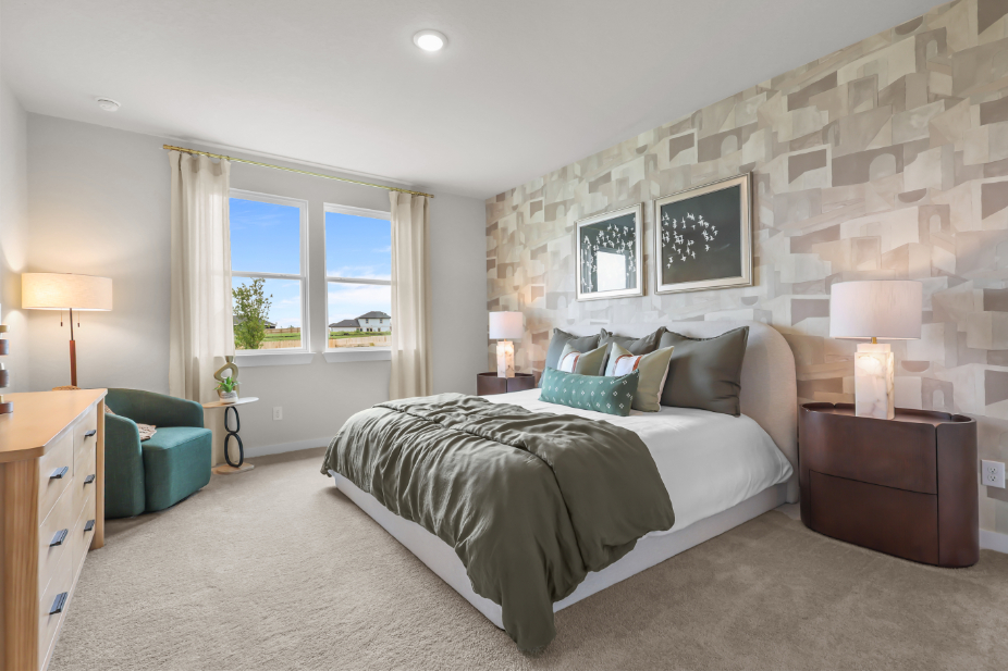 A bedroom with a bed and a chair.