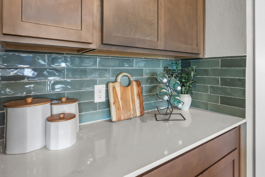 A kitchen counter with a plant and a vase of flowers.
