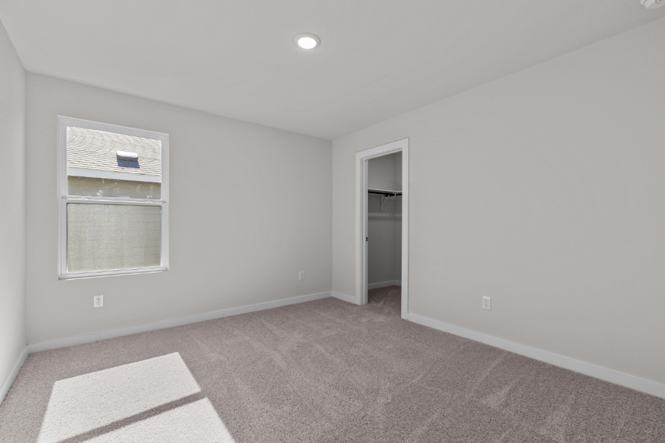 A room with a carpet and a window.