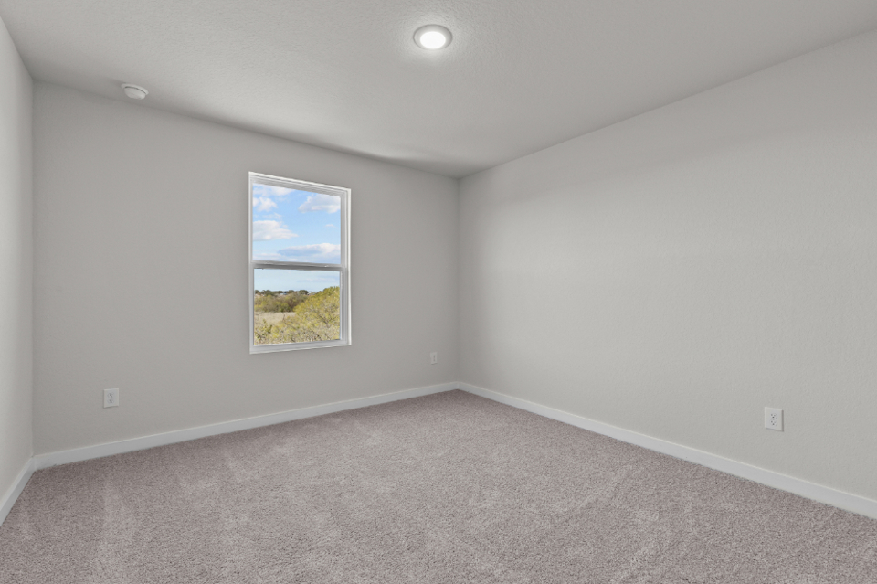 A room with a window and a painting on the wall.
