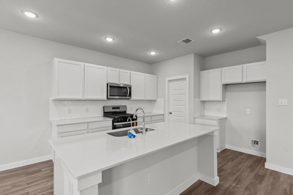 A kitchen with white cabinets.