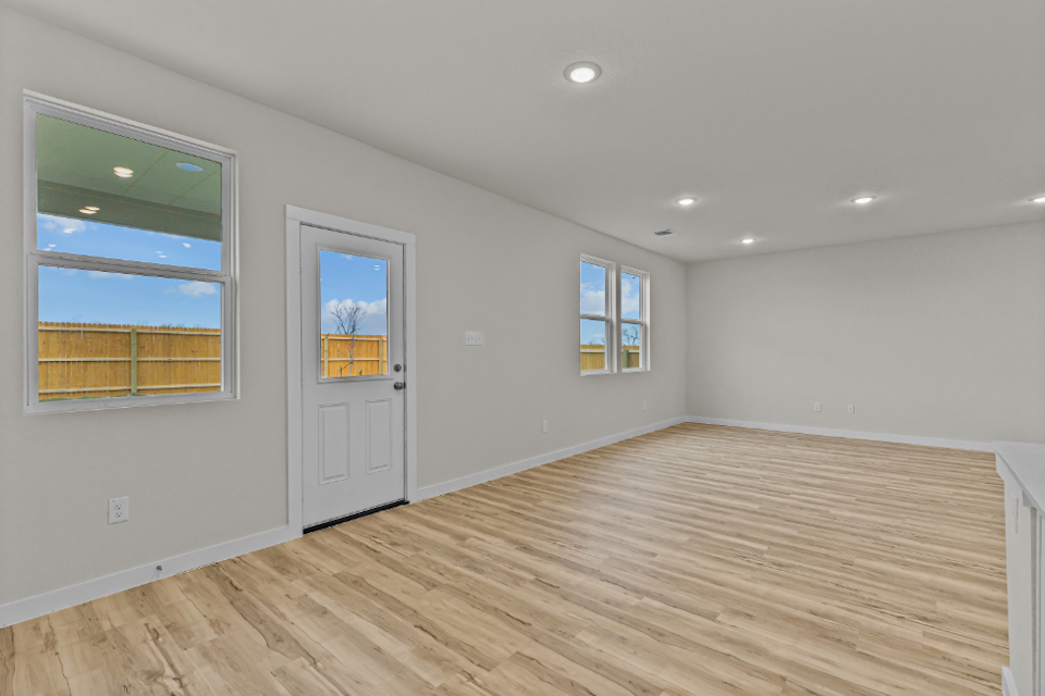 A room with a wood floor and windows.