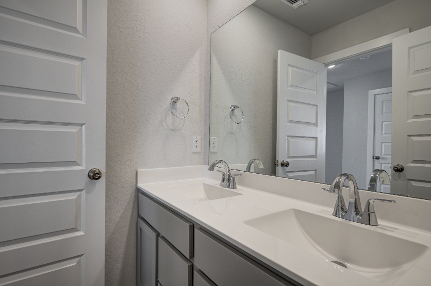 A bathroom with a large mirror.