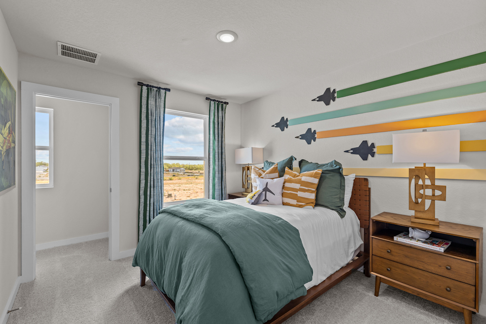 A bedroom with a bed and a desk.