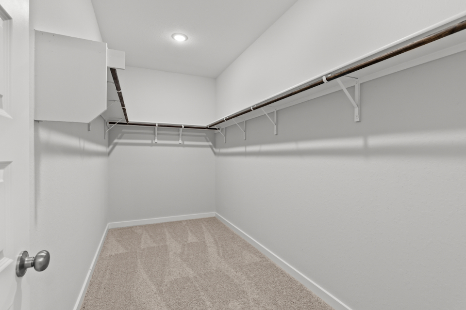 A white hallway with a metal railing.