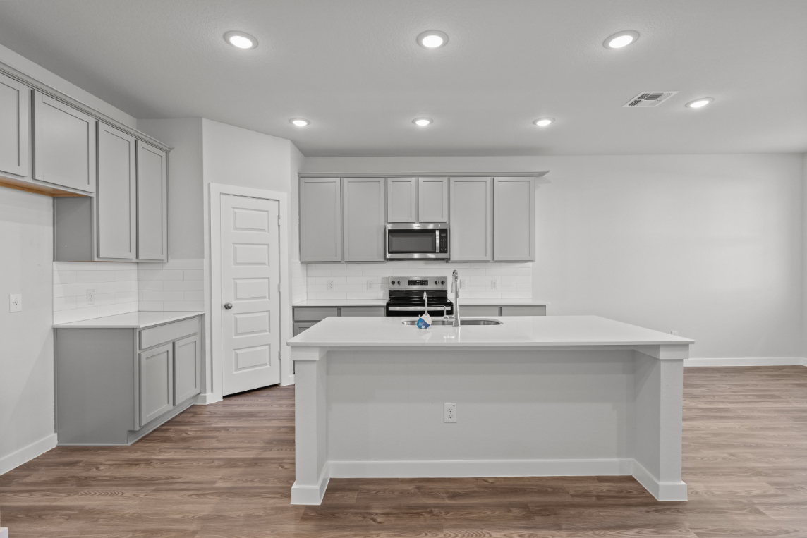 A kitchen with white cabinets.