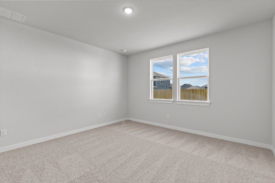 A room with a window and a carpet.