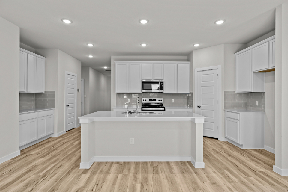 A kitchen with white cabinets.