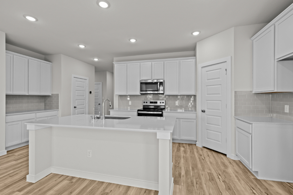 A kitchen with white cabinets.