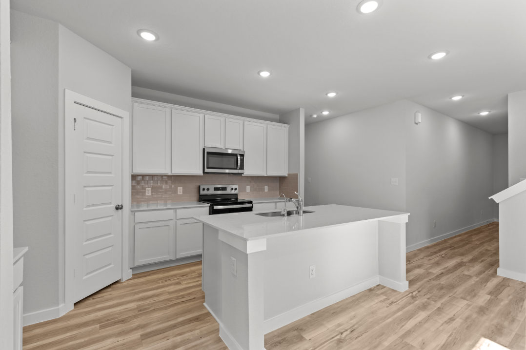 A kitchen with white cabinets.