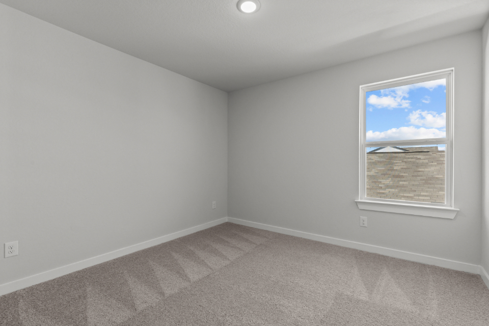 A room with a window and a carpet.