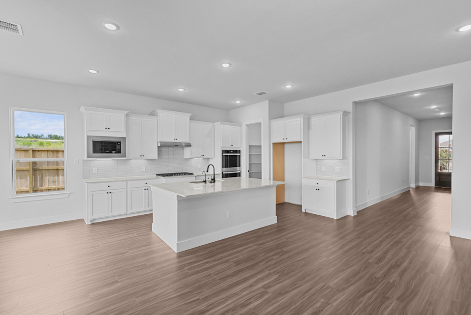 A kitchen with white cabinets.