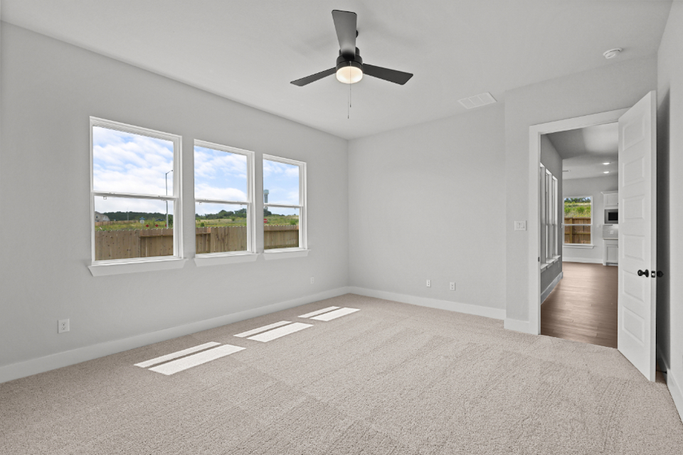 A room with a ceiling fan and a window.