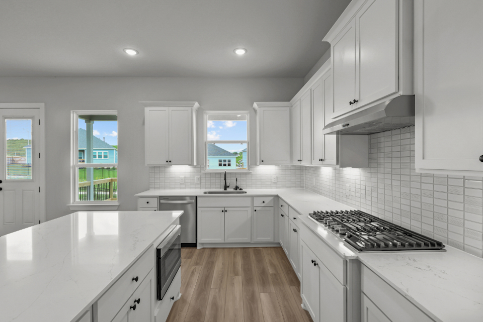 A kitchen with white cabinets.