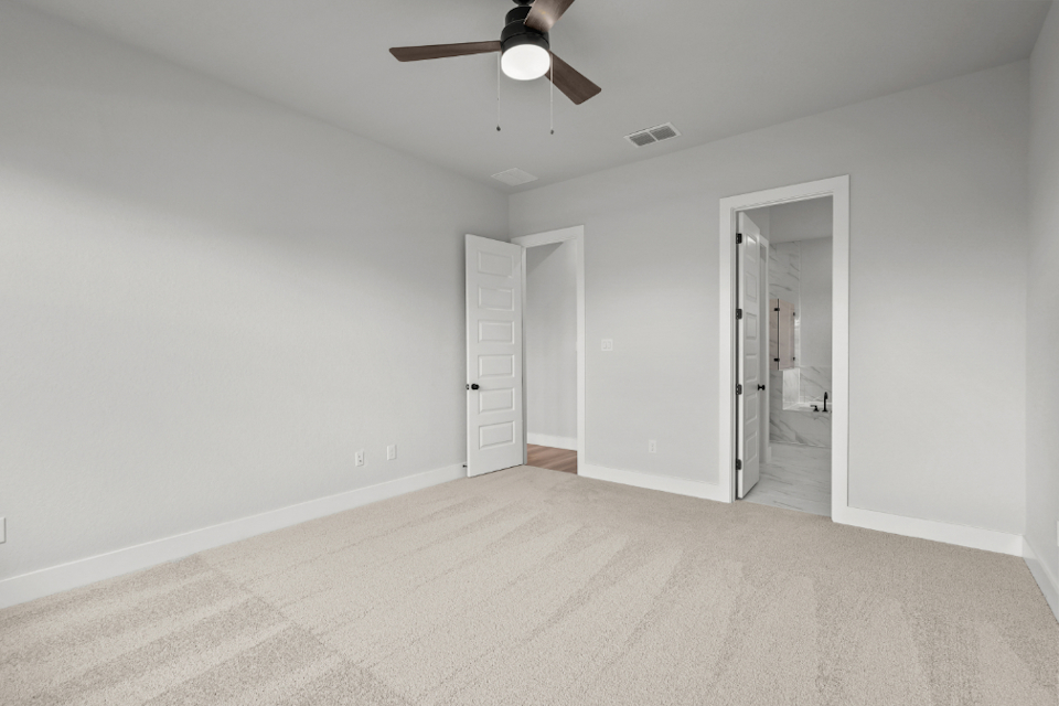 A room with a ceiling fan and a door.