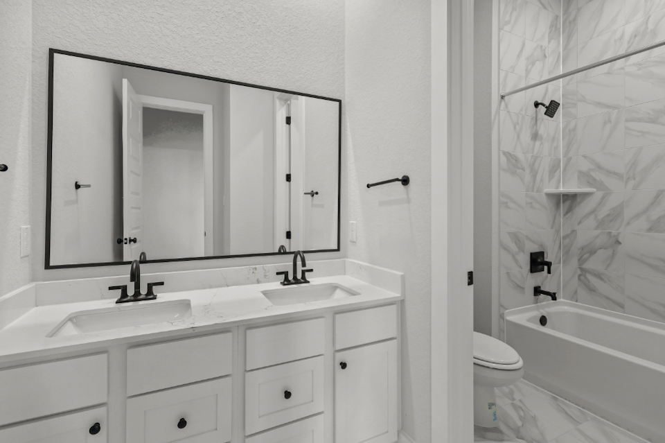 A bathroom with a tub sink and toilet.