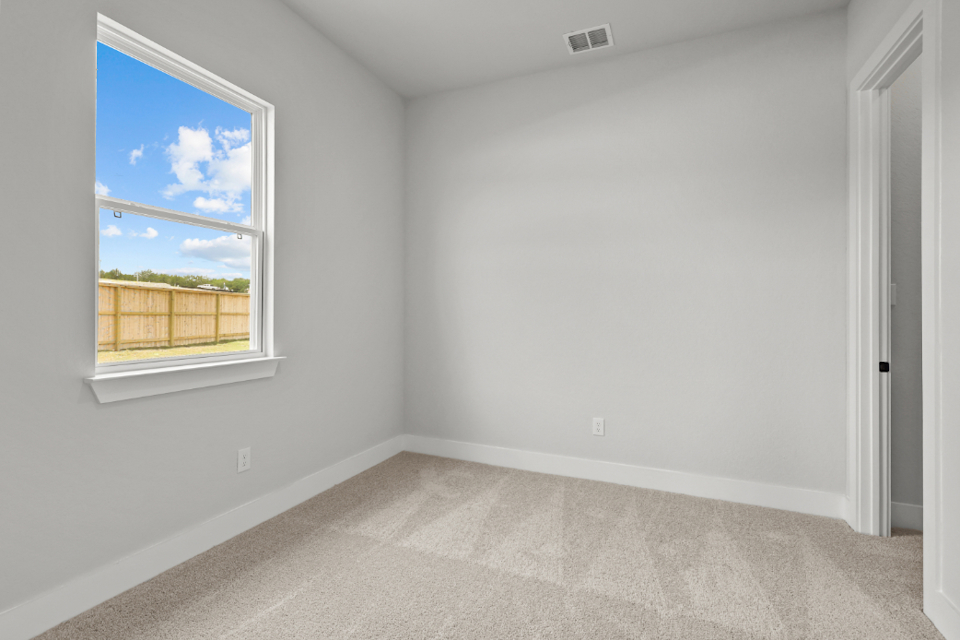 A room with a window and a rug.