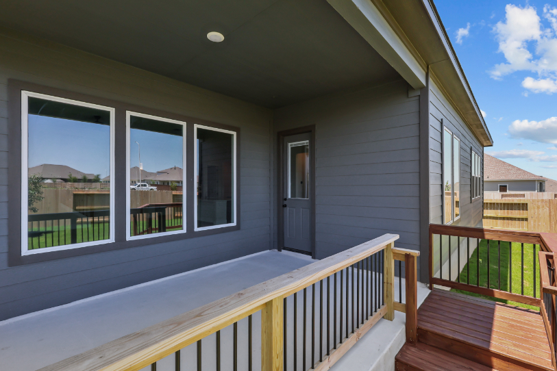 A deck with a railing and windows.