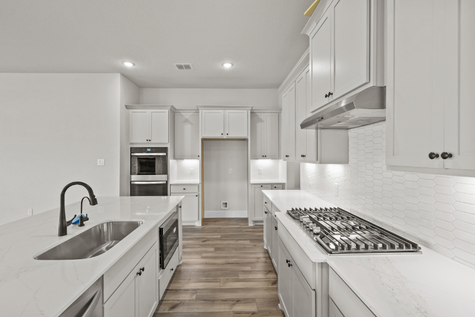 A kitchen with white cabinets.