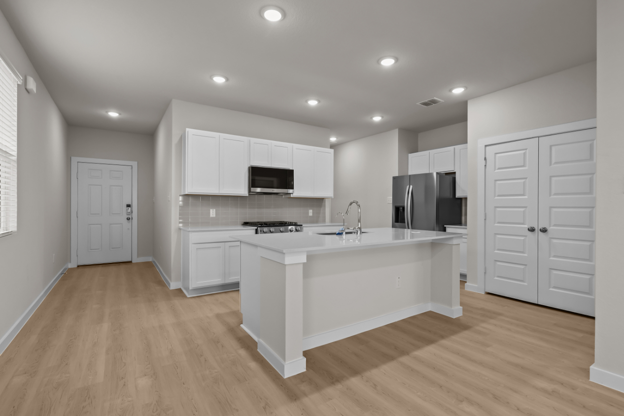 A kitchen with white cabinets.