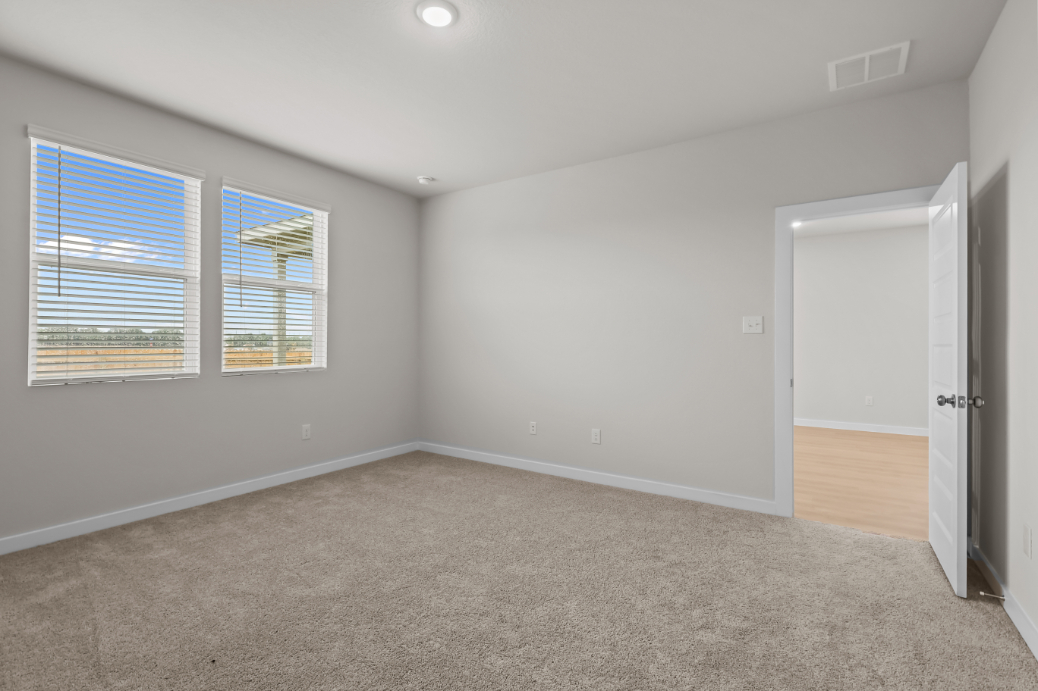 A room with a carpet and windows.