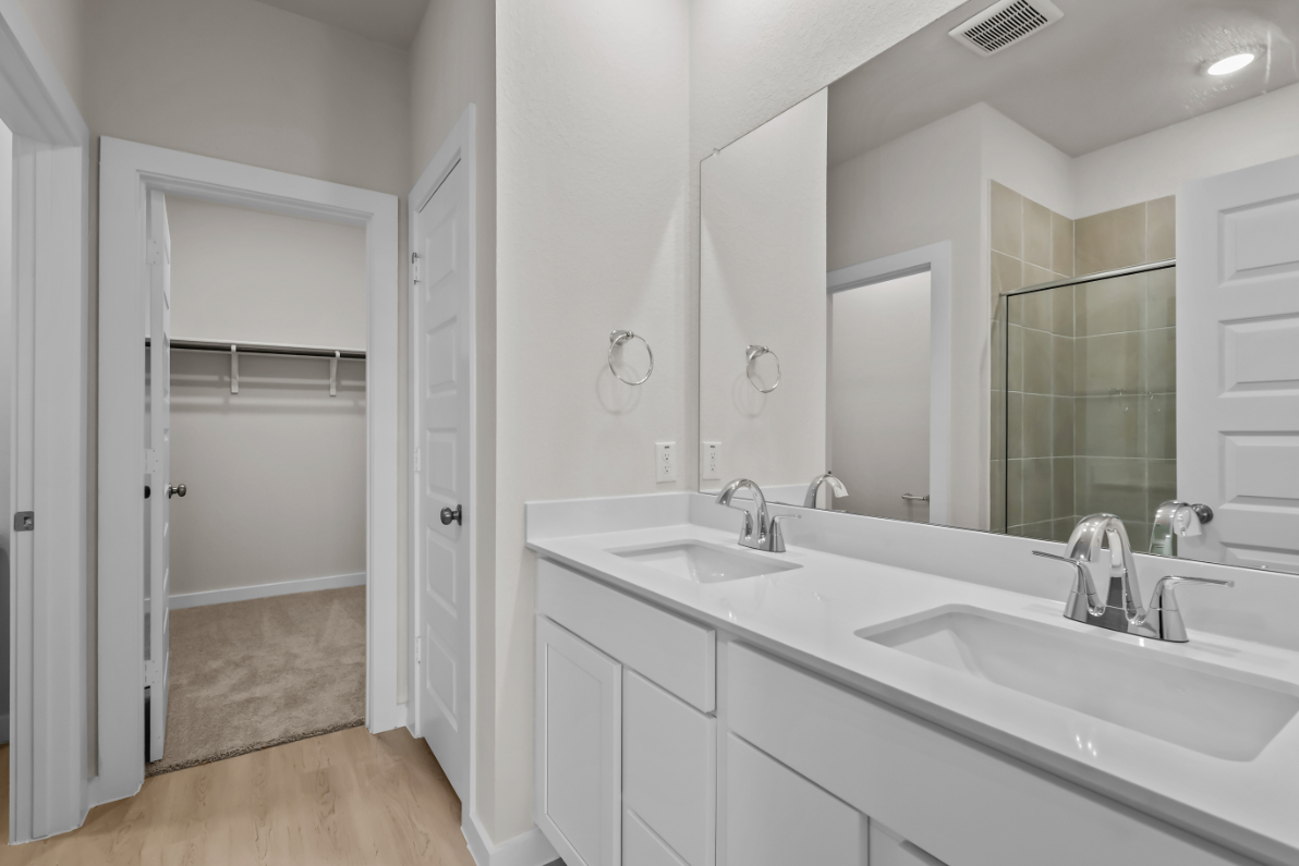 A bathroom with white cabinets.