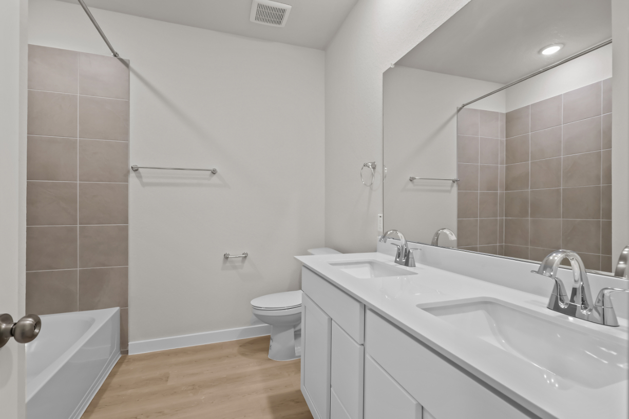 A bathroom with a tub sink and toilet.