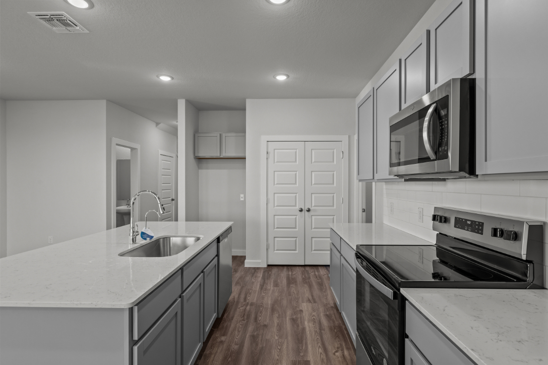 A kitchen with white cabinets.