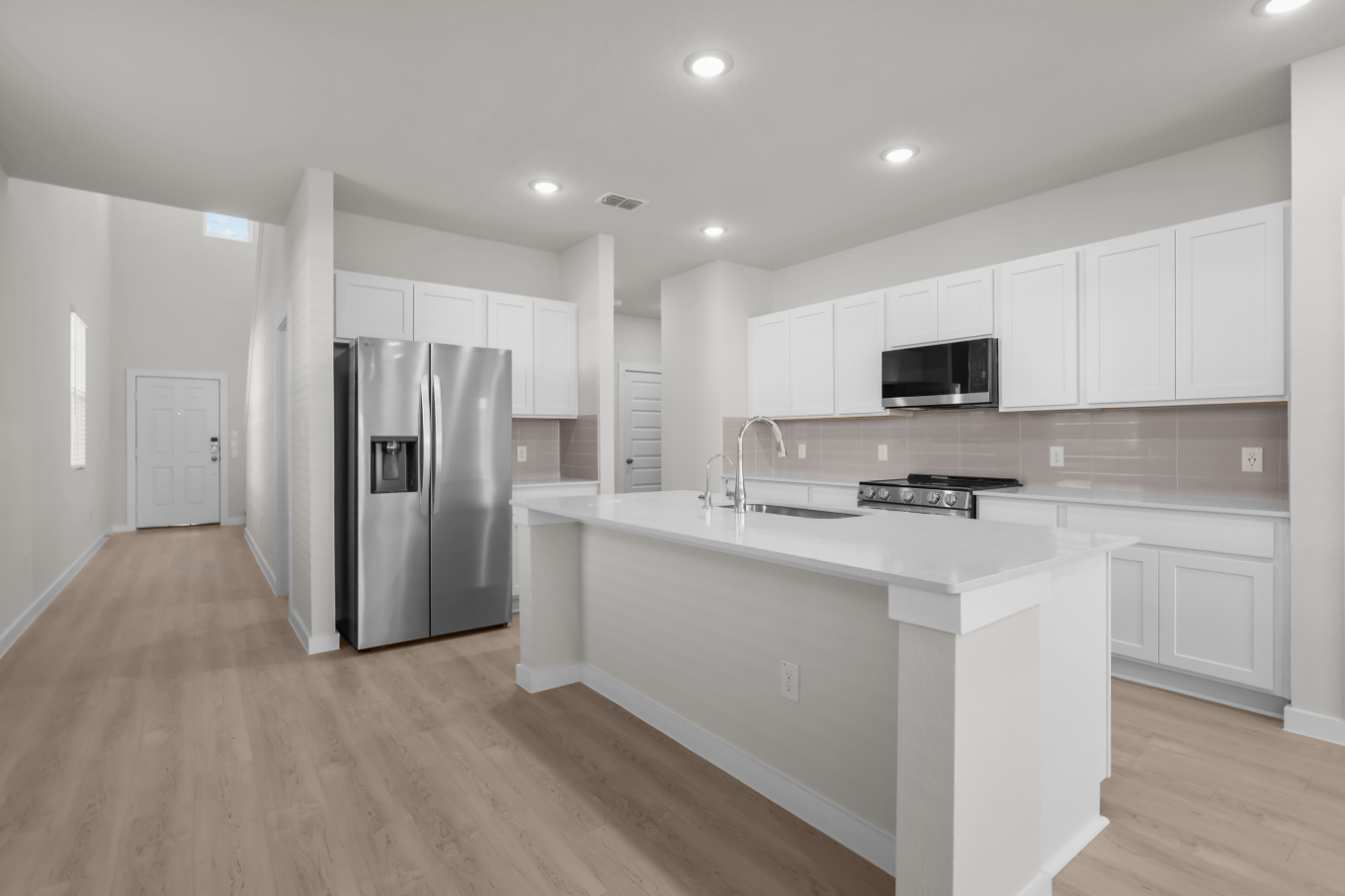 A kitchen with white cabinets.