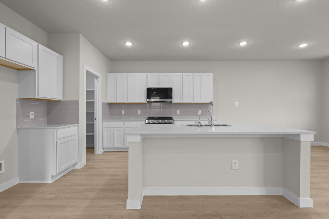 A kitchen with white cabinets.