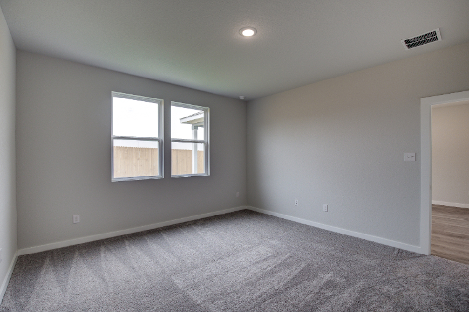 A room with a carpet and windows.