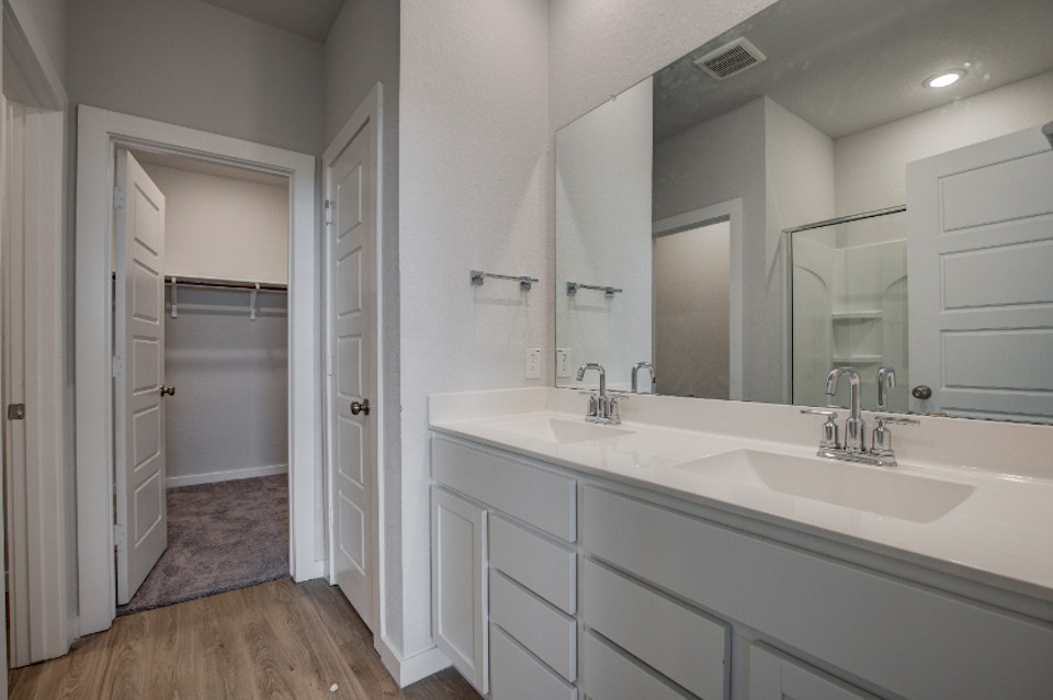 A bathroom with white cabinets.