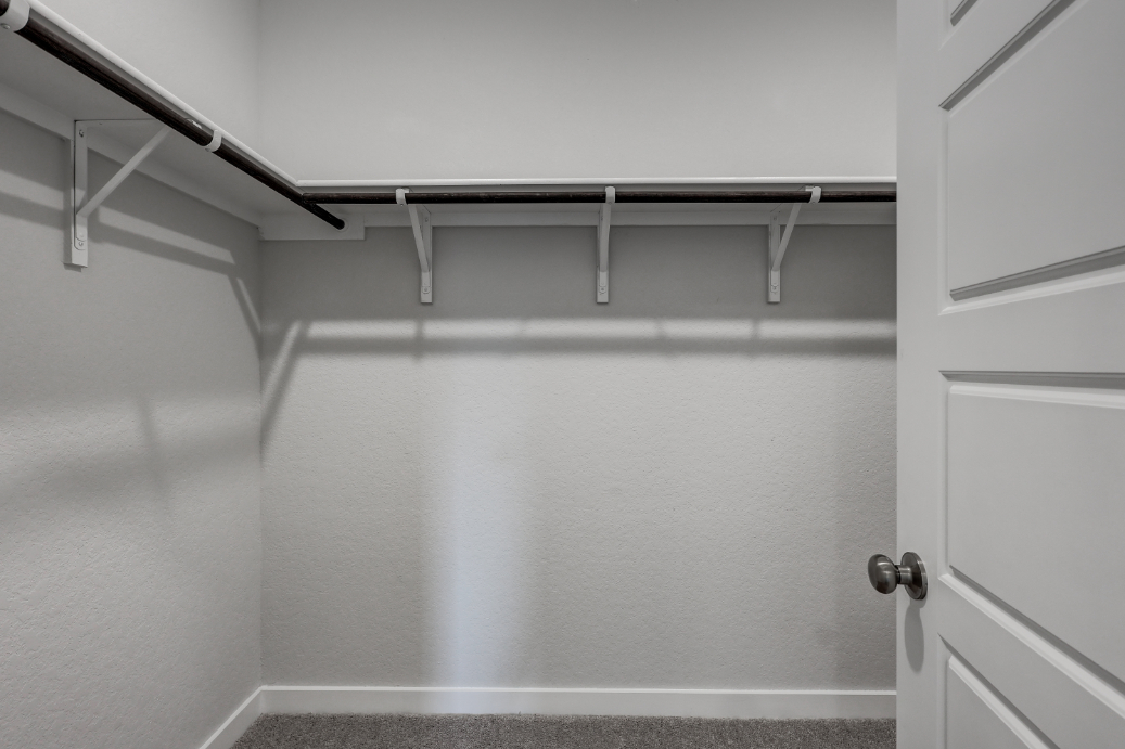 A white wall with a metal bar.