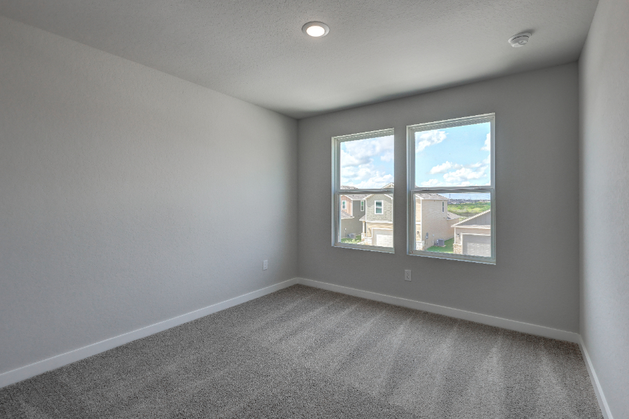A room with a window and a carpet.