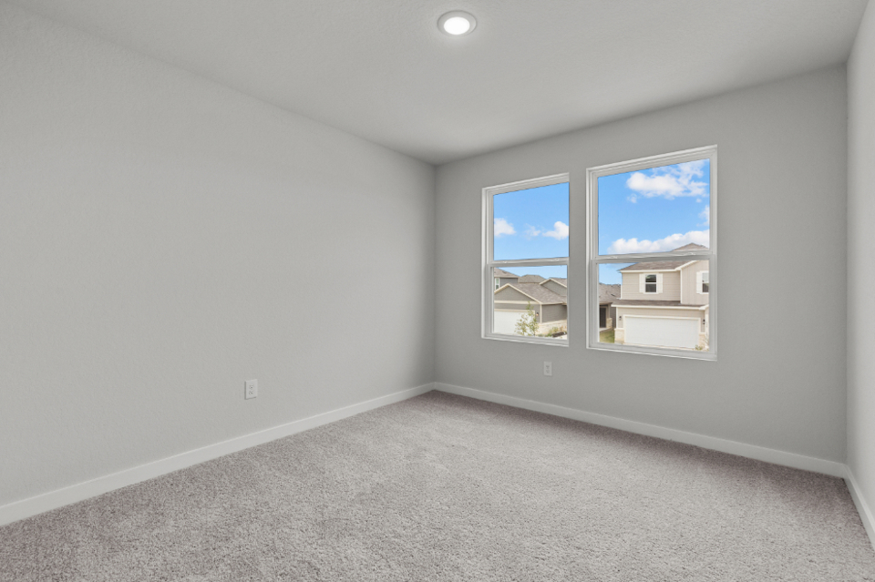 A room with a window and a carpet.