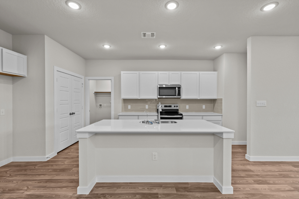 A kitchen with white cabinets.