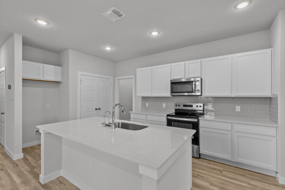 A kitchen with white cabinets.