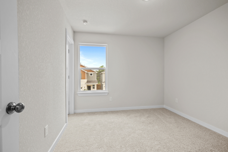 A room with a window and a carpet.