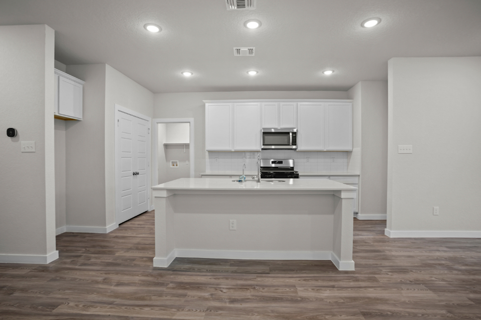 A kitchen with white cabinets.